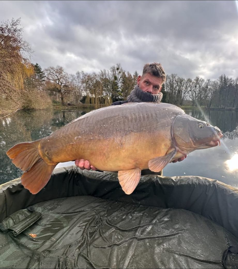 Mark Poole, owner of Willow Pool France, holding a large mirror carp