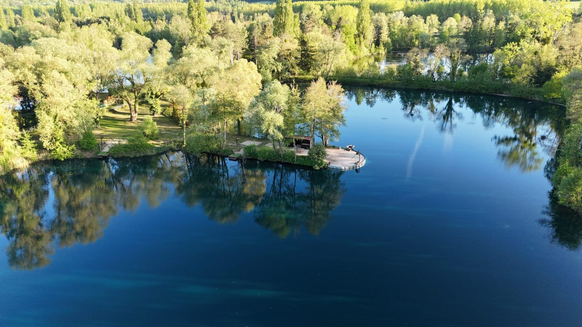Aerial view of Willow Pool France, a 5-acre carp fishing lake surrounded by trees